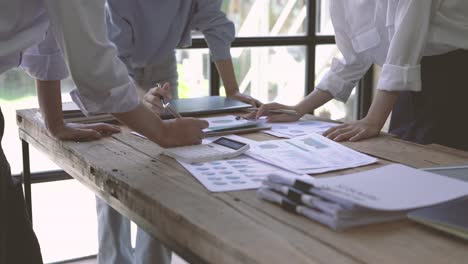 businessman and businesswomen pointing finger at plans, three people business.