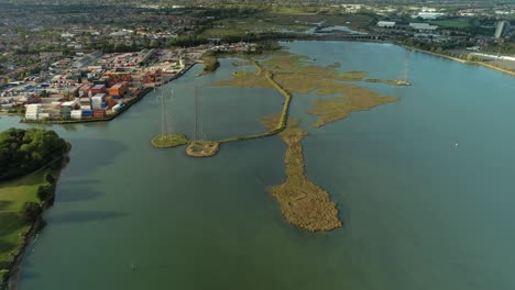 High-voltage-transmission-towers-also-known-as-electricity-pylons,-seen-from-an-aerial-perspective-near-Southampton-England