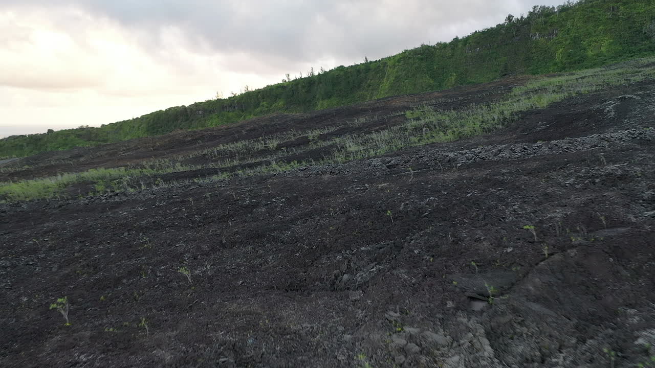 Penerbangan di atas lanskap vulkanik lava kering di Pulau Reunion.