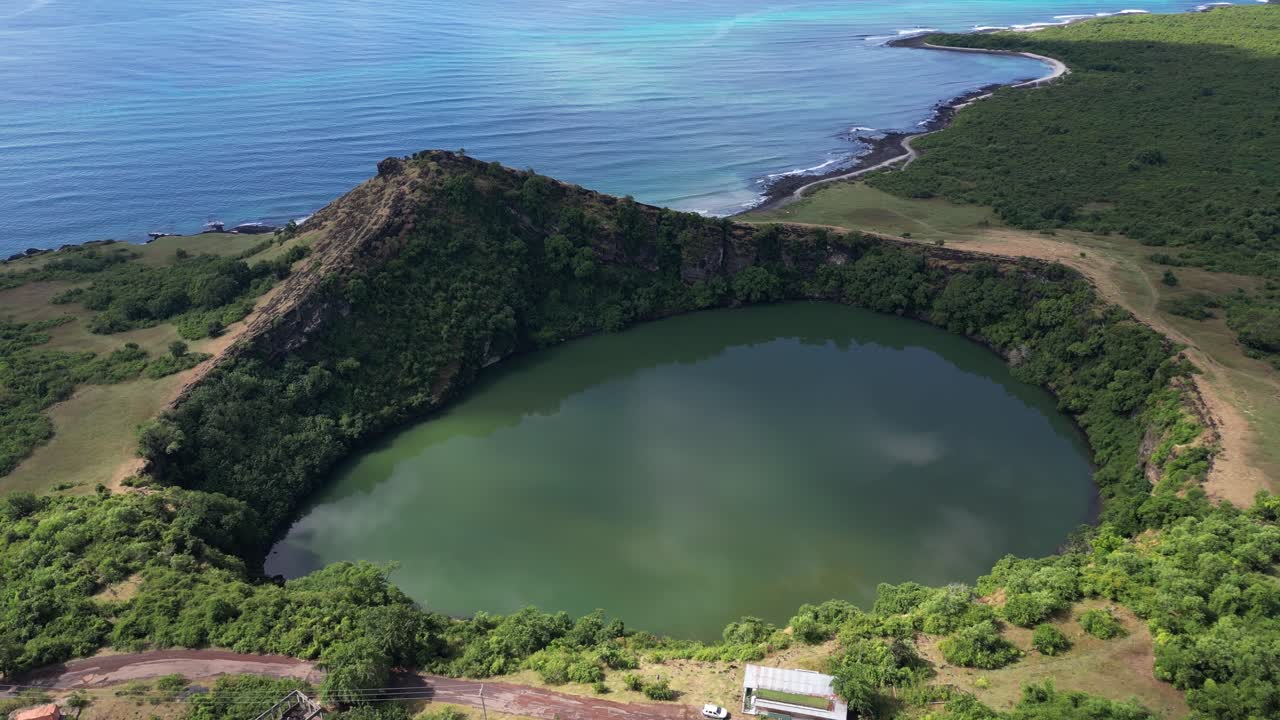 코모로스 섬의 푸른 바다를 내려다보는 절벽과 초록색으로 둘러싸인 푸른 물과 화산 크레이터 호수의 공중 풍경