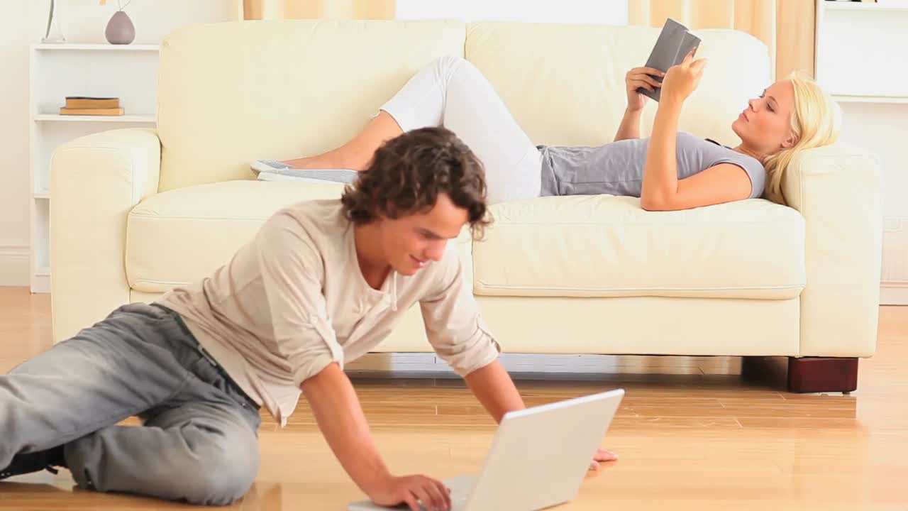 Woman reading a book and man surfing the web