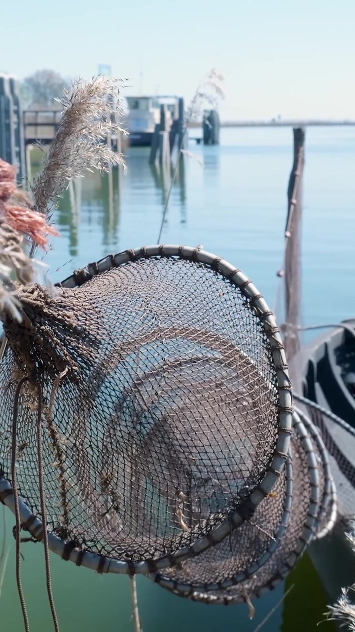 Vecchia rete da pesca appesa vicino al mare calmo e blu