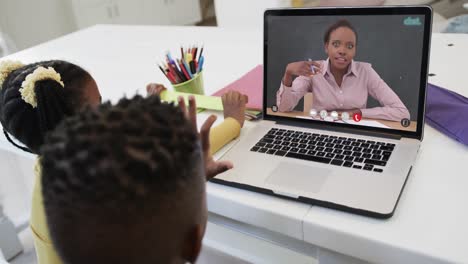 Afroamerikanischer-Junge-Und-Mädchen-Auf-Laptop,-Online-Lernen-Mit-Einer-Gemischtrassigen-Lehrerin
