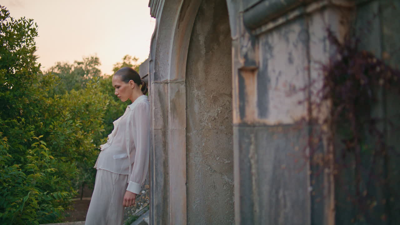 леди расслабляется древняя архитектура опирается на старую стену. женщина стоит на террасе