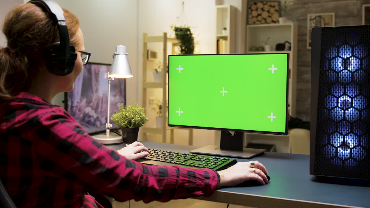 Woman using computer with green screen
