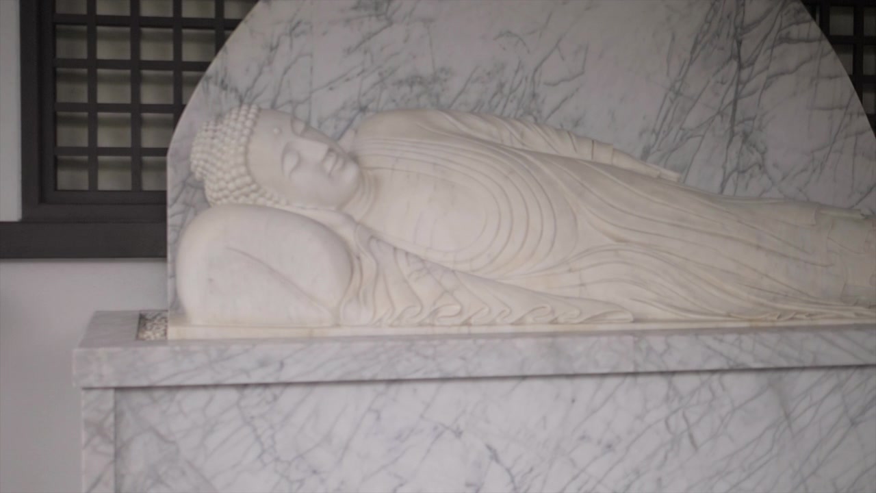 Statua di Buddha reclinato in marmo esposta all'interno di un tempio a Kyoto, Giappone.