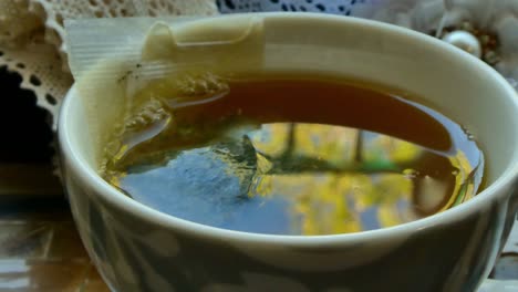 putting a cup of tea in a tray with materials for sewing