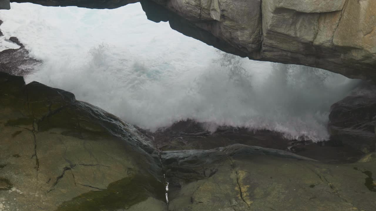 Slow motion shot of water flowing beneath the majestic Natural Bridge, showcasing the power of nature and water's smooth movement.