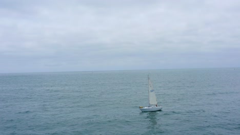 A-beautiful-aerial-drone-shot,-a-static-shot-of-a-sailboat-in-the-ocean,-Dana-Point---Orange-County---California