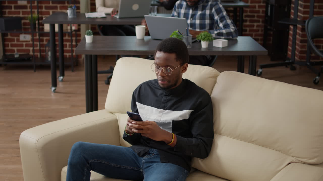 Young man using smartphone to text messages and browse internet