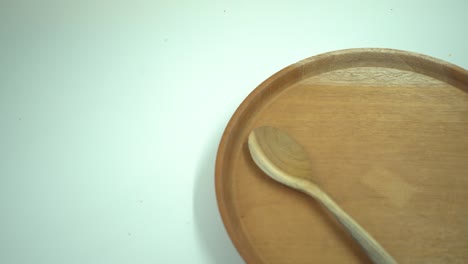 fotografía de cerca de un plato de madera vacío, un tenedor y una cuchara, con fondo blanco para el espacio de copia.