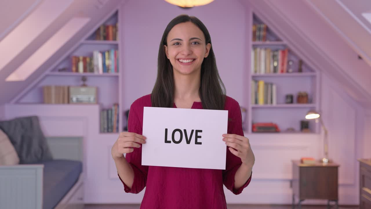 Happy Indian woman holding LOVE banner