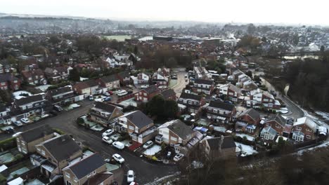 snowy aerial village residential neighbourhood winter frozen north west houses and roads reversing shot