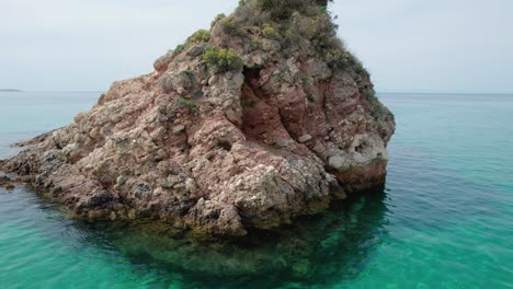 Aerial-View-Near-Metalia-Beach-With-Turquoise-Water-And-A-Small-Rocky-Island,-Thassos,-Greece,-Europe