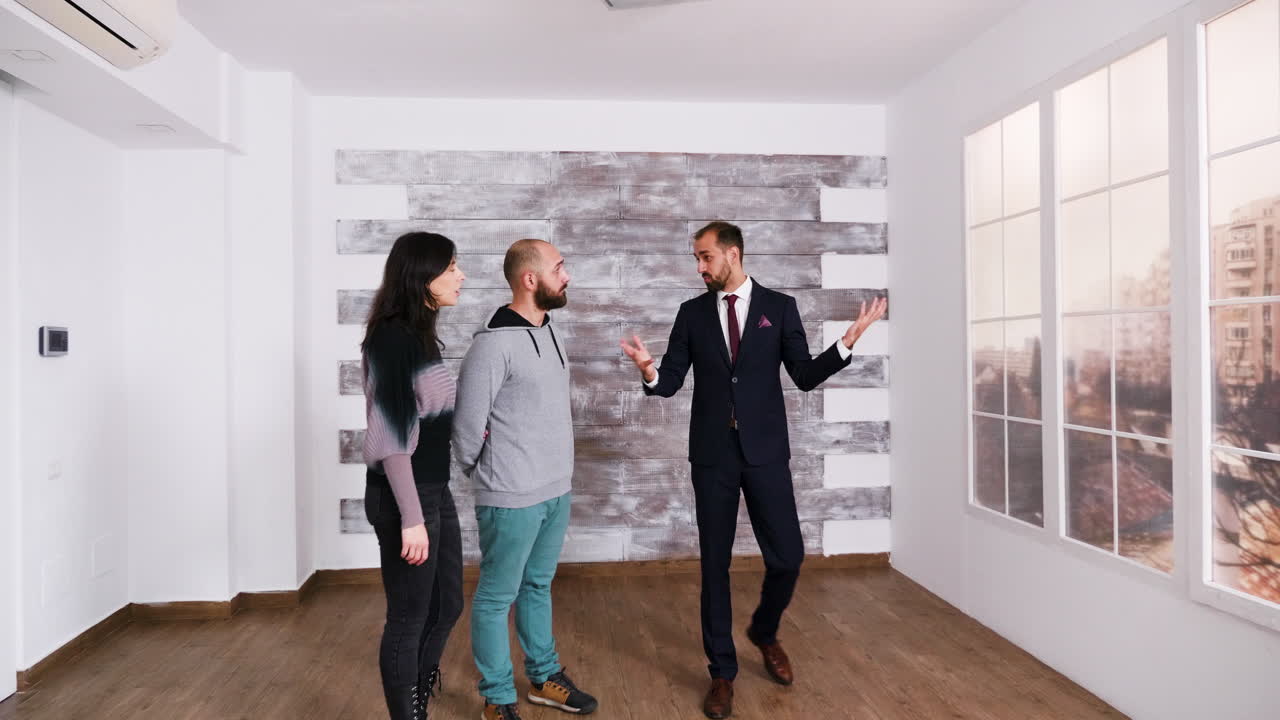 Agent immobilier présentant une maison à un couple