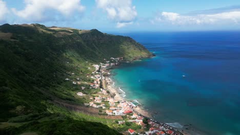 coastal village and lush mountains meet turquoise waters in a scenic aerial view