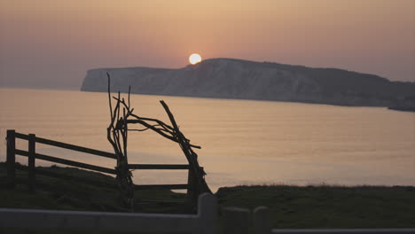 wooden archway in front of sunset over sea