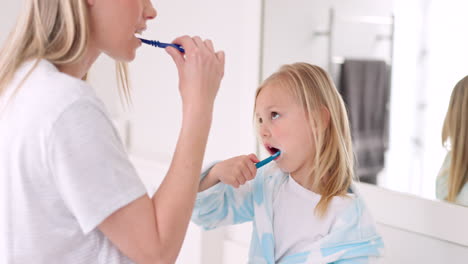 mother and daughter brushing teeth