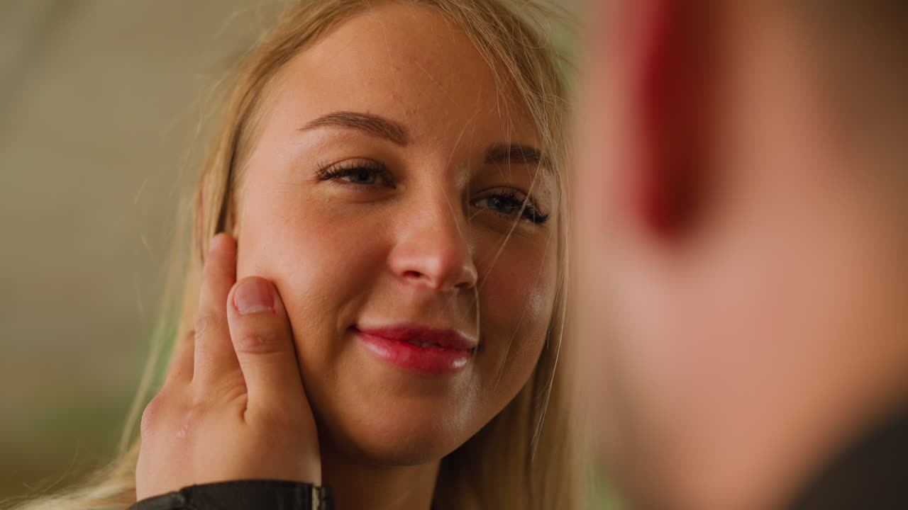 Pen kvinne smiler til sin elskede mann som stryker kinnet hennes