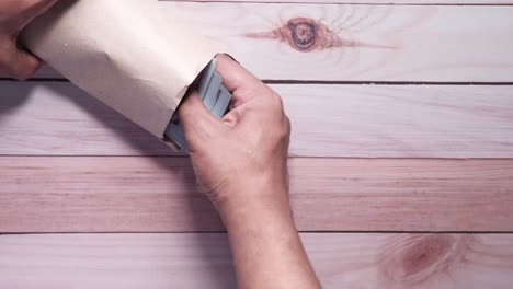 hands handling money in brown paper envelope