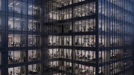 modern office building with illuminated interiors and people working at night