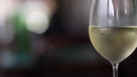 a detailed view of a chilled wine glass with a blurred background, highlighting condensation and clarity.