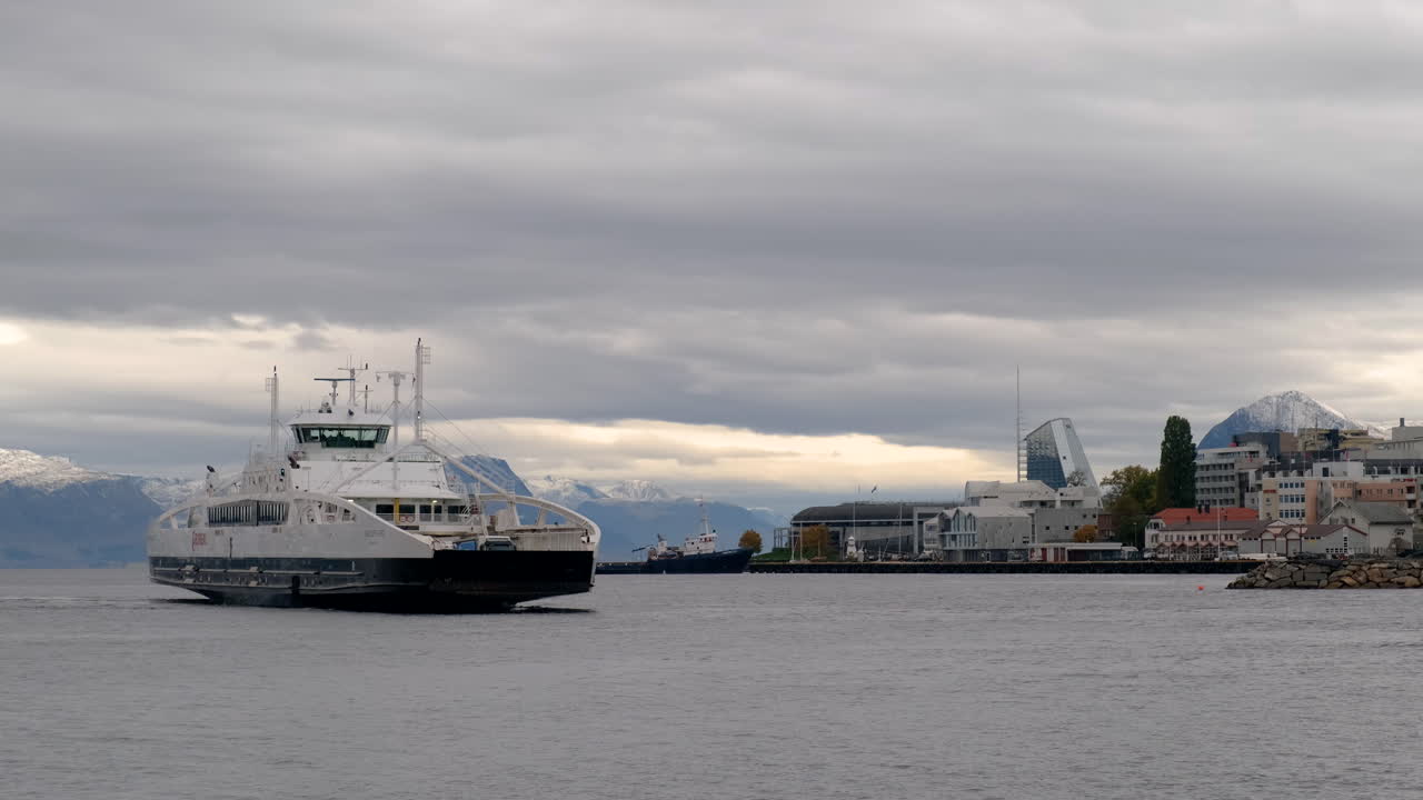ferry que llega al puerto de molde en un día nublado con vistas a las montañas en el fondo, noruega
