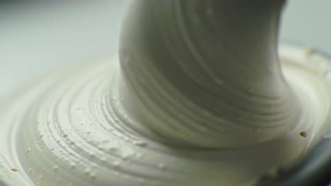close-up of a smooth creamy mixture being stirred at a kitchen countertop highlights culinary techniques. the process showcases the importance of consistency in cooking and baking.