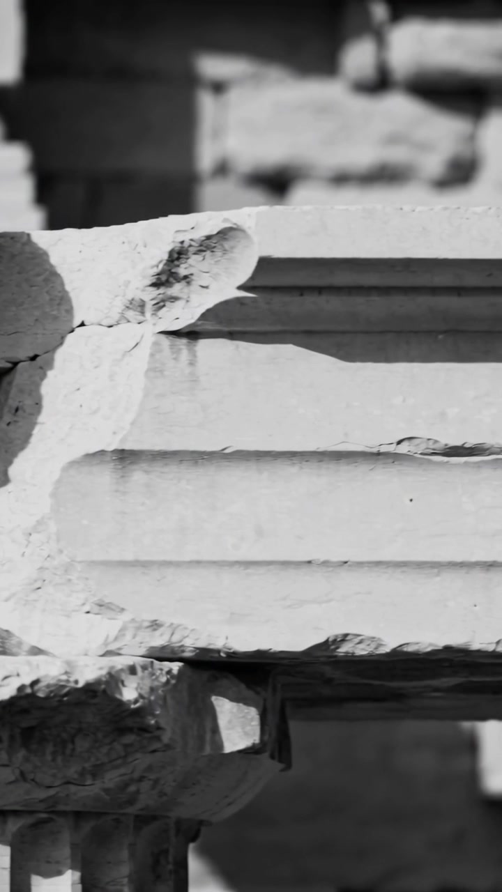 Vertical video: Panning camera revealing carved lintel and blocks at ruin, documenting aged cracks