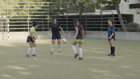 Lange-Aufnahme-Von-Fußballspielerinnen,-Die-Fußball-Im-Kreis-Auf-Dem-Feld-Trainieren-Und-Treten