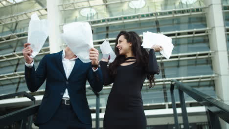 young businessman and businesswoman laughing near stadium