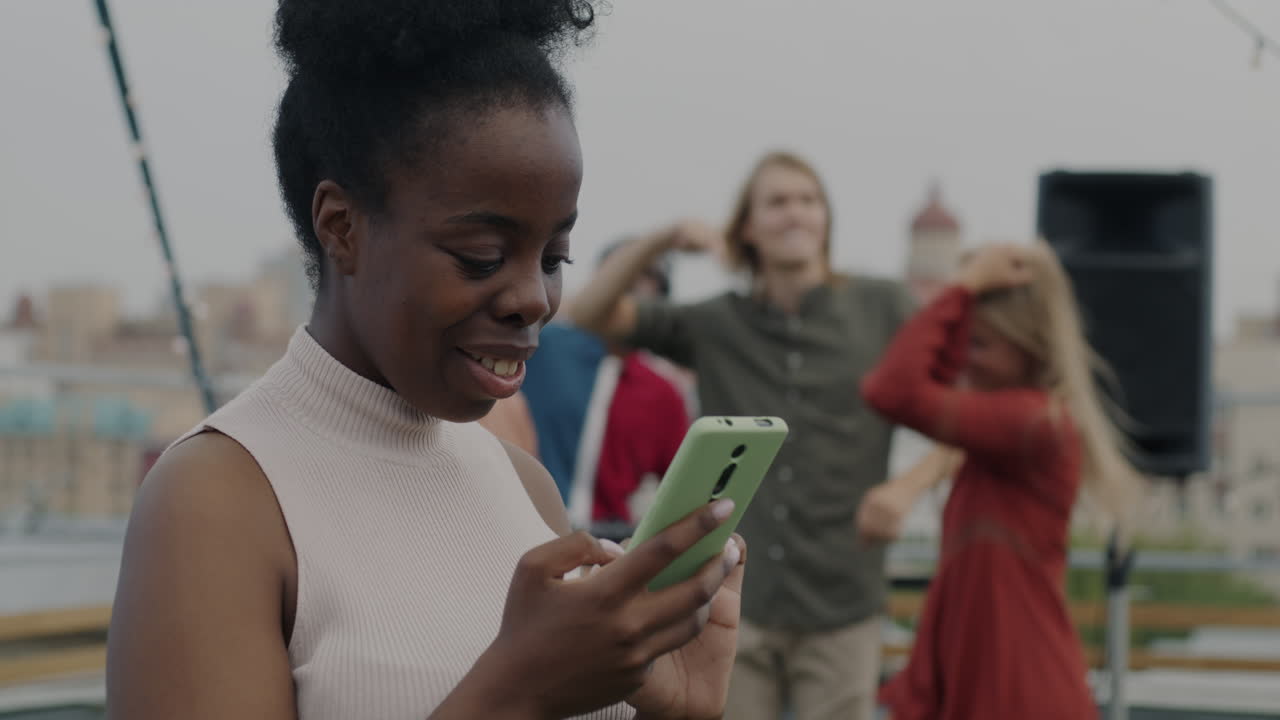 Femme utilisant son téléphone lors d'une fête sur un toit