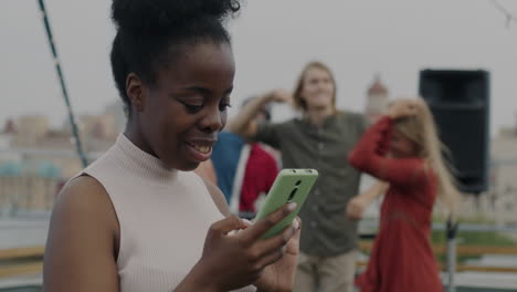 woman using phone at rooftop party