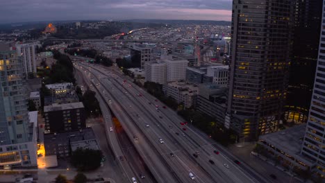 Vista-Aérea-De-Los-Vehículos-Que-Circulan-Por-La-Autopista-Para-Entrar-Y-Salir-De-Seattle-Durante-La-Noche