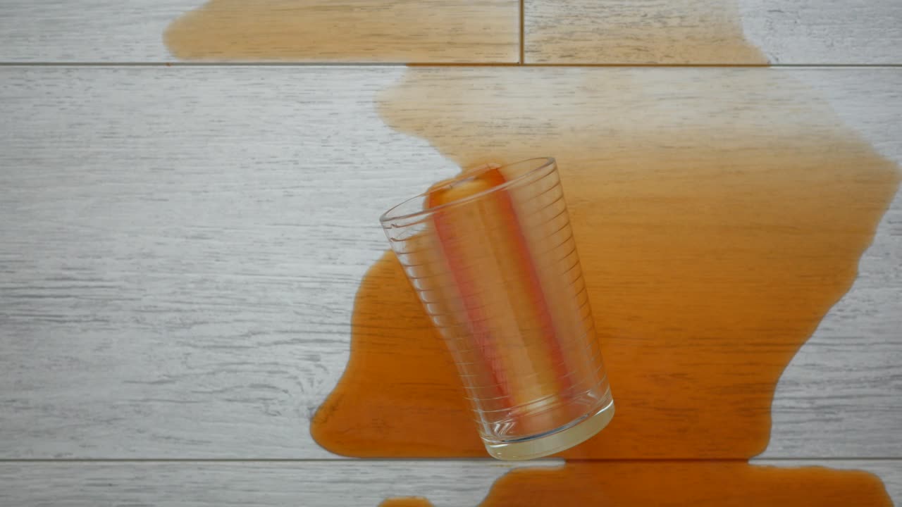 Sølt appelsinjuice på et flislagt gulv