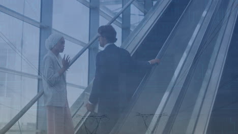 animation of financial data and graphs over diverse businessman and businesswoman on escalator