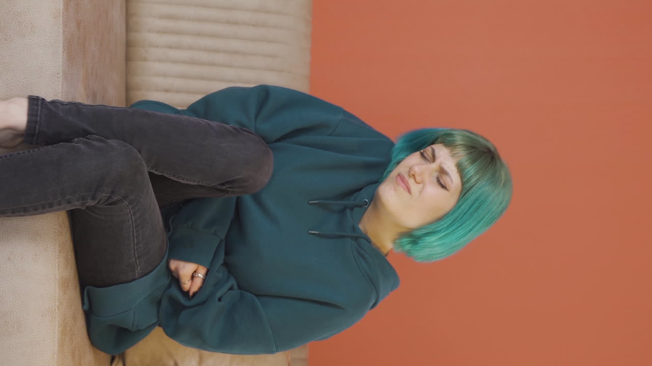 video vertical de una mujer joven con dolor de estómago.