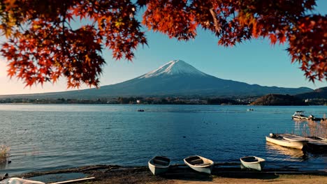 a serene autumn scene at lake kawaguchiko, featuring stunning views of mount fuji framed by vibrant red momiji foliage.