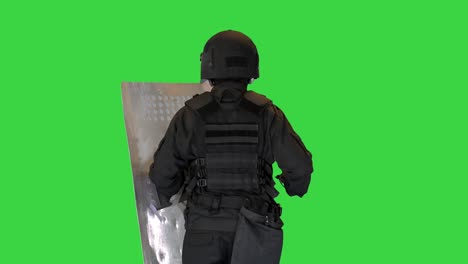 riot policeman running with a shield and baton on a green screen, chroma key