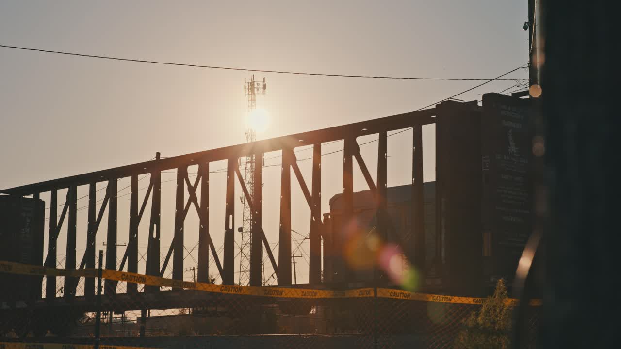 공허한 화물차와 함께 화물 열차는 태양 발광과 함께 황금 시간 동안 느린 속도로 움직입니다.