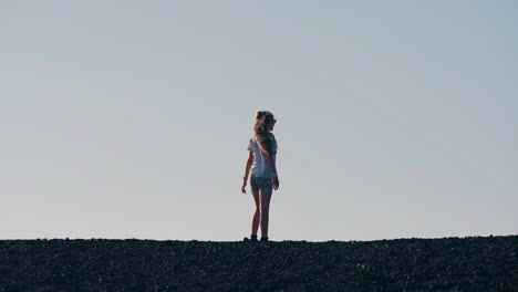 silhouette of a person standing on a desolate horizon against a clear sky