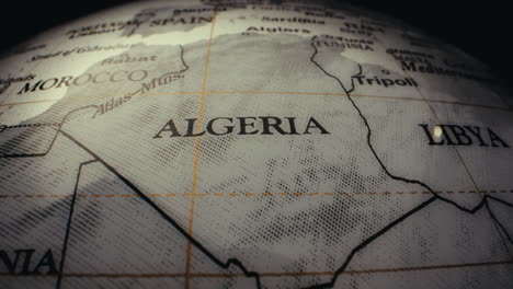 close-up of a vintage world globe, focusing on the region of algeria, morocco, and libya