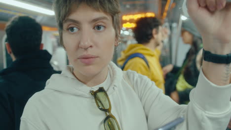woman using phone in subway train during the ride