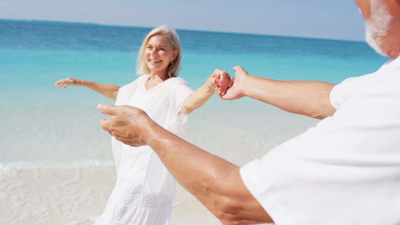 카리브 해변에서 함께 춤을 추는 고위 백인 커플