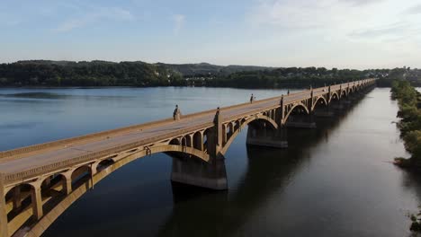 reverse aerial wide angle drone shot of traffic crossing bridge above susquehanna river between columbia and wrightsville, pennsylvania, usa