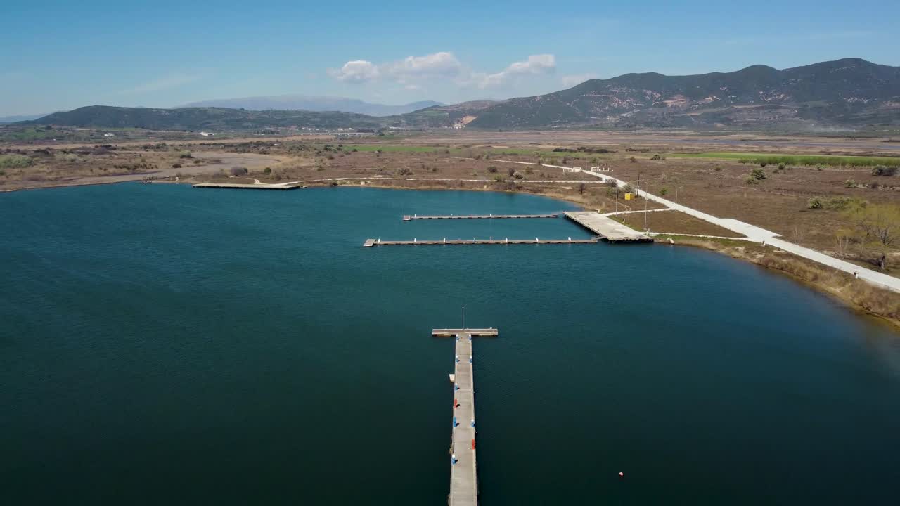Aerial pull back over small abandoned port on lake,lagoon on a sunny day
