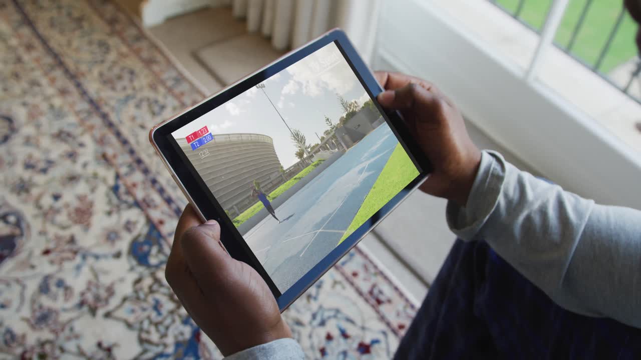 compuesto de un hombre sentado en casa, viendo el evento de jabalina de atletismo en la tableta