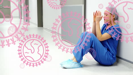 animation of pink globe and people logos, over distressed female surgeon in hospital corridor