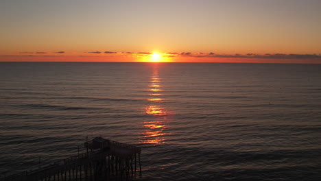 Ocean-fishing-pier-drone-reveal-at-sunrise