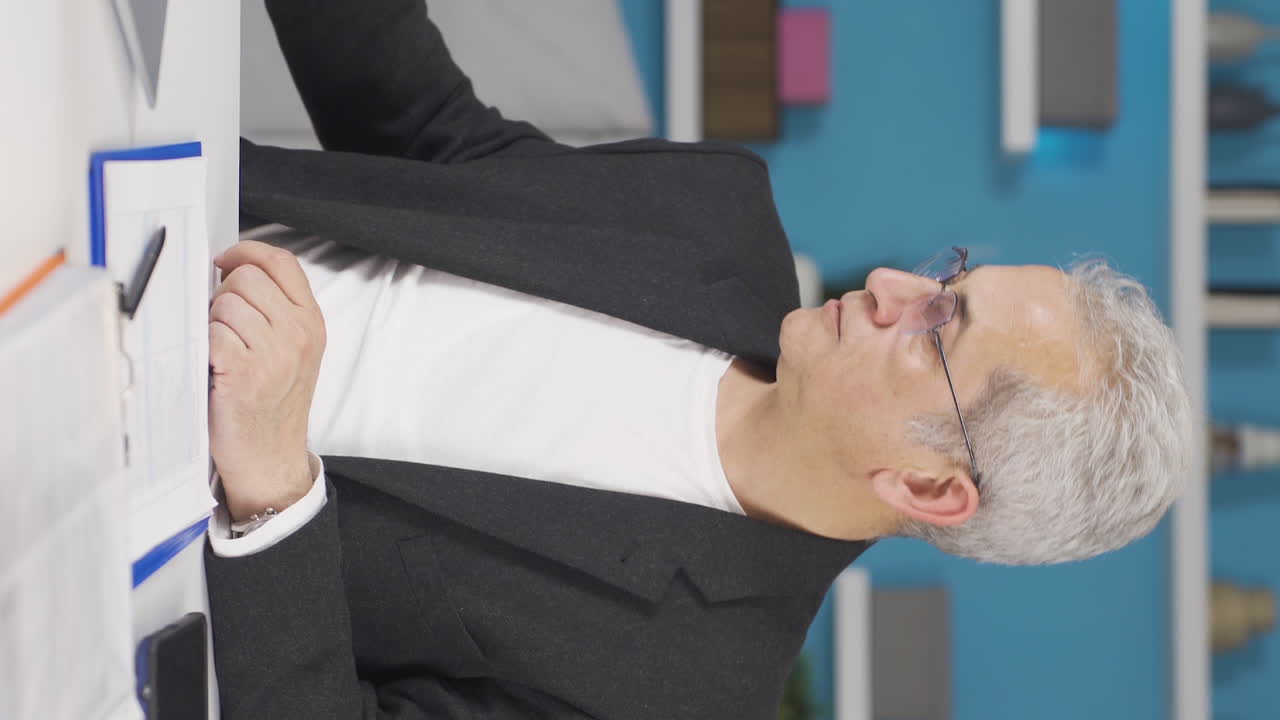 홈 오피스 근로자의 수직 비디오 남자는 공격적이고 폭력에 중독되어 있습니다.